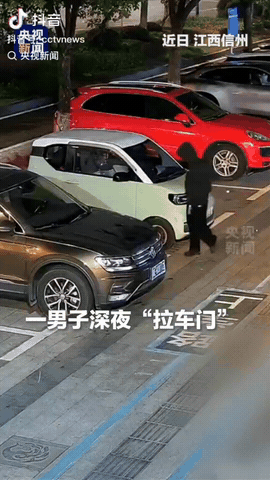 深夜，江西信州的一处停车区，一男子捂着口罩，帽衫的帽子也套在头上，他在停着的车子