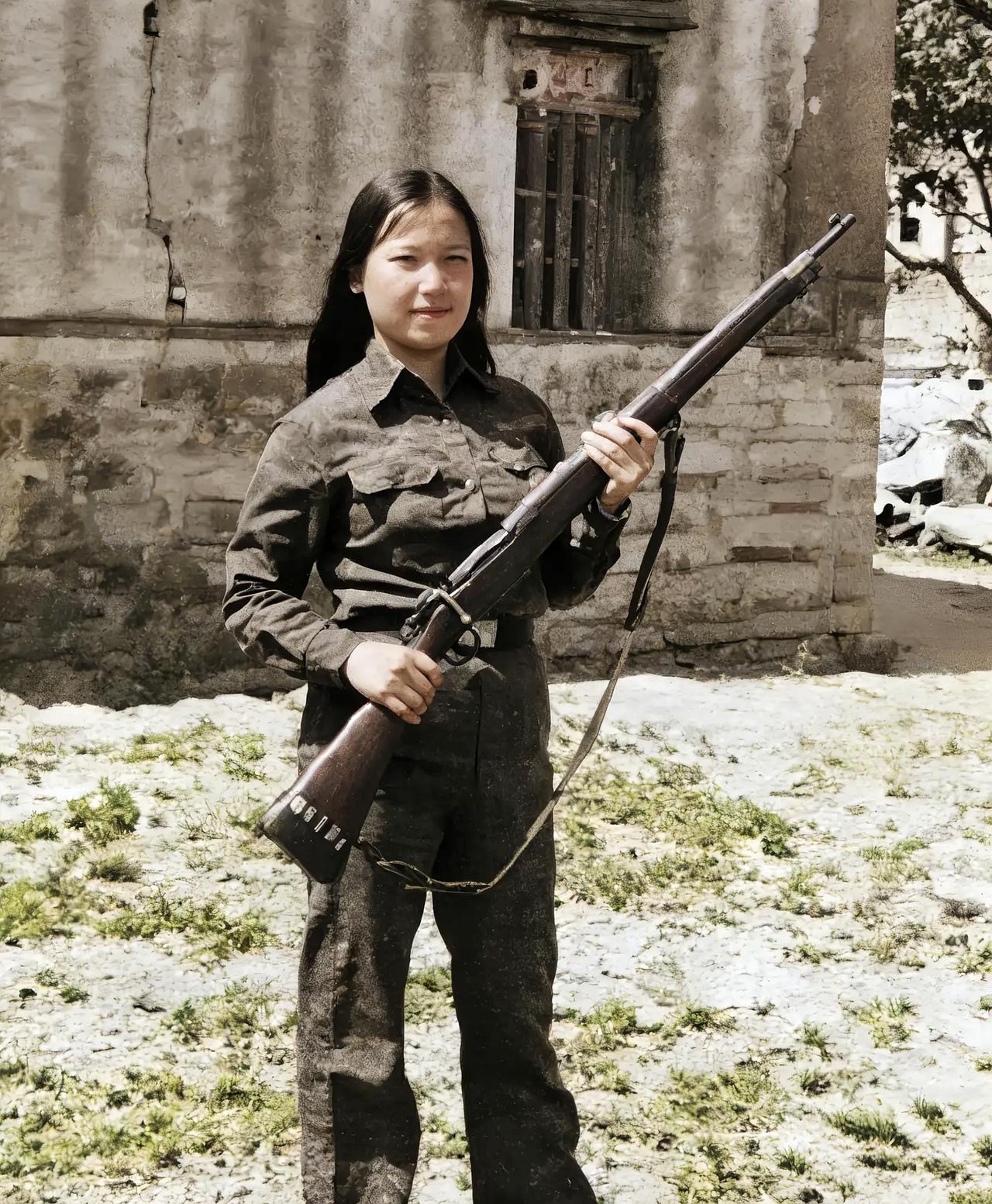 这是战地记者拍摄到中国抗战女兵。一身黑色的装束，一头飘逸的长发，手持钢枪，神采奕