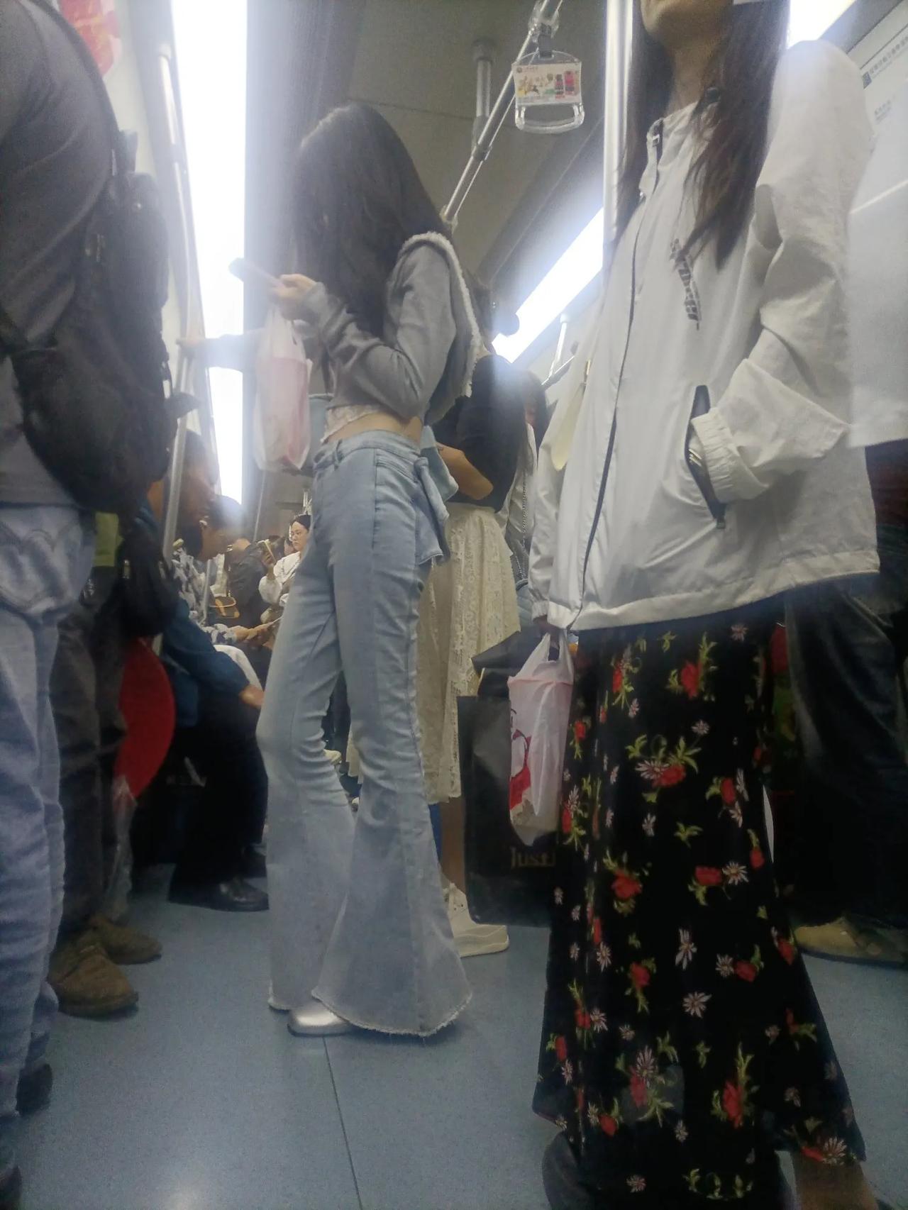 地铁上穿牛仔喇叭裤的姑娘。