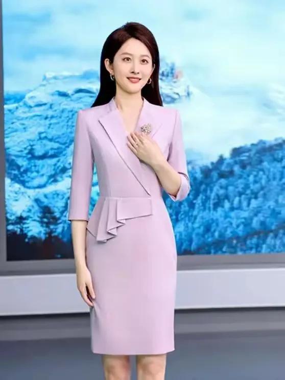 一袭紫色制服勾勒曼妙身姿，主持人气质卓然，往台上一站便成全场瞩目焦点。