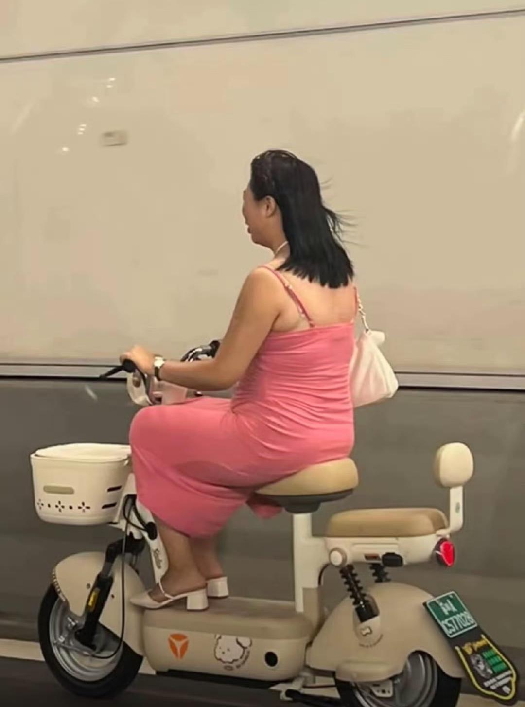 这就是堵了整个南京扬子江隧道的靓女，粉色吊带战袍非常亮眼，微胖身材。头盔没带，骑
