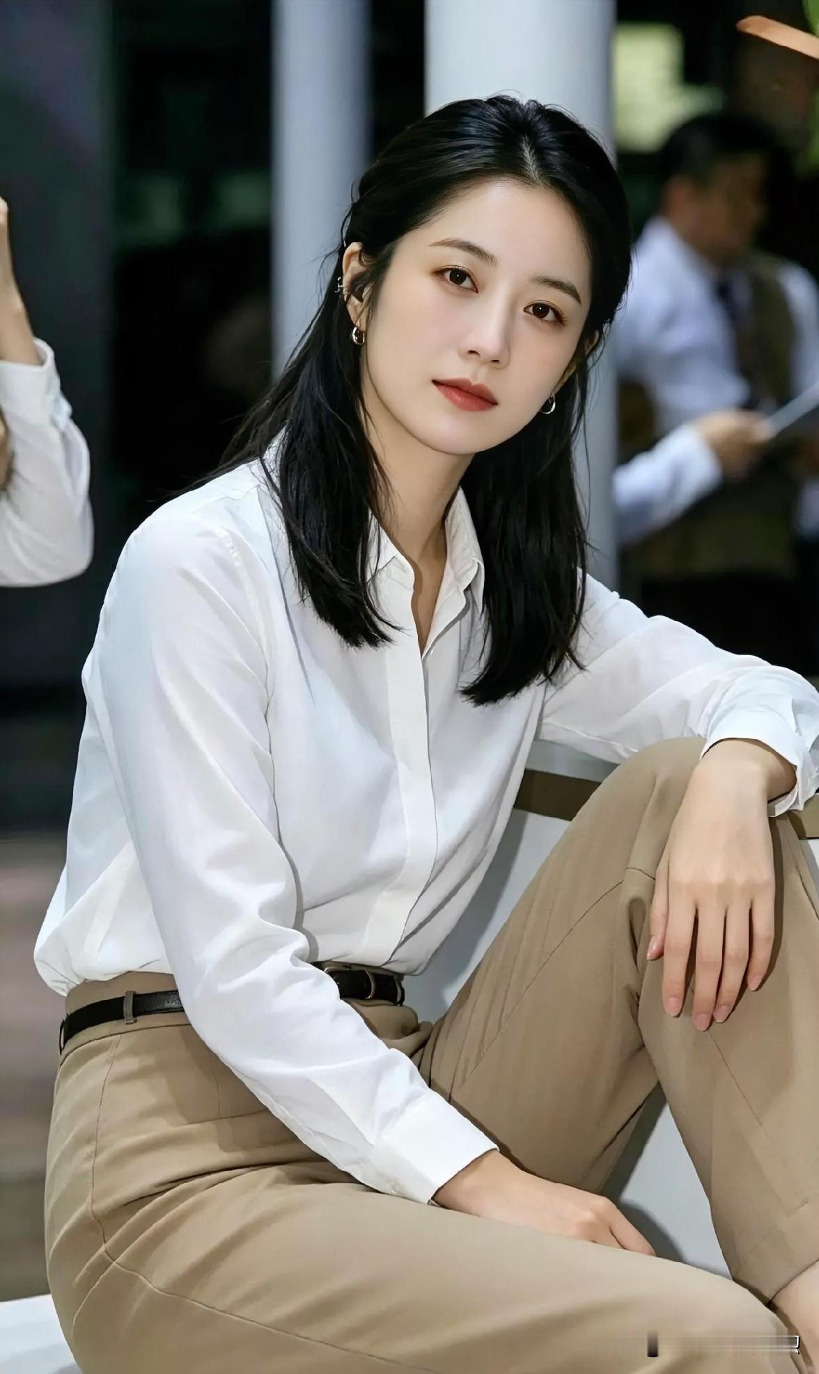 素白衬衫裹挟清雅，卡其裤装沉淀从容。墨发垂肩，眸光沉静如秋水。于喧嚣中独坐，她是