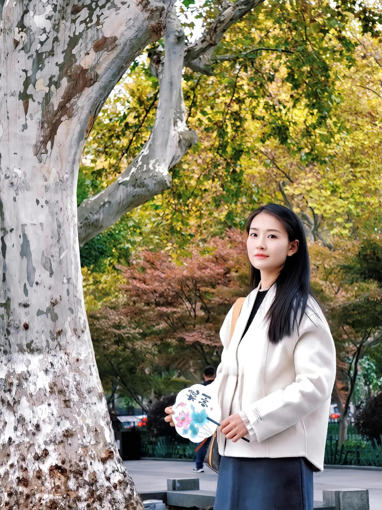 秋日漫步，树影婆娑，手持团扇，悠然自得。