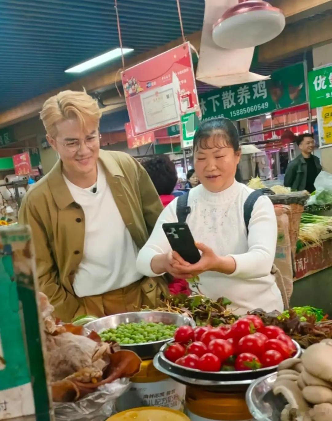 47岁吴克群现身贵州遵义菜市场买菜，他打扮时尚又不失个性，他穿着大衣外套，他染了