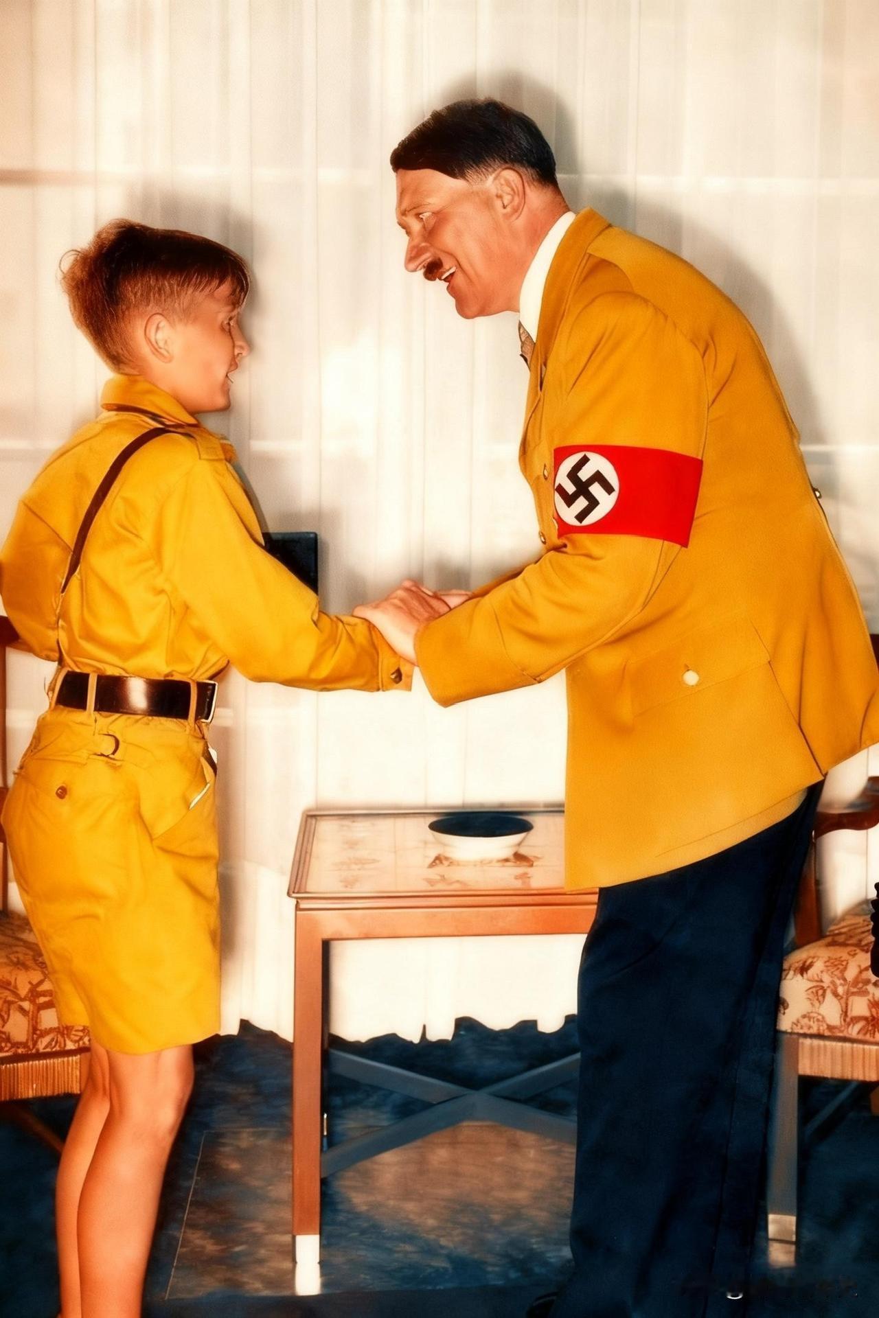 1936年，柏林，阿道夫·希特勒正在与一名“希特勒青年团”成员握手。这个孩子名叫