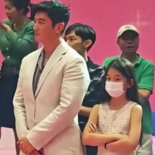 她10岁，第一次在镜头前站直了。双手抱胸，眼神没躲。旁边是穿两件外套的杜江，