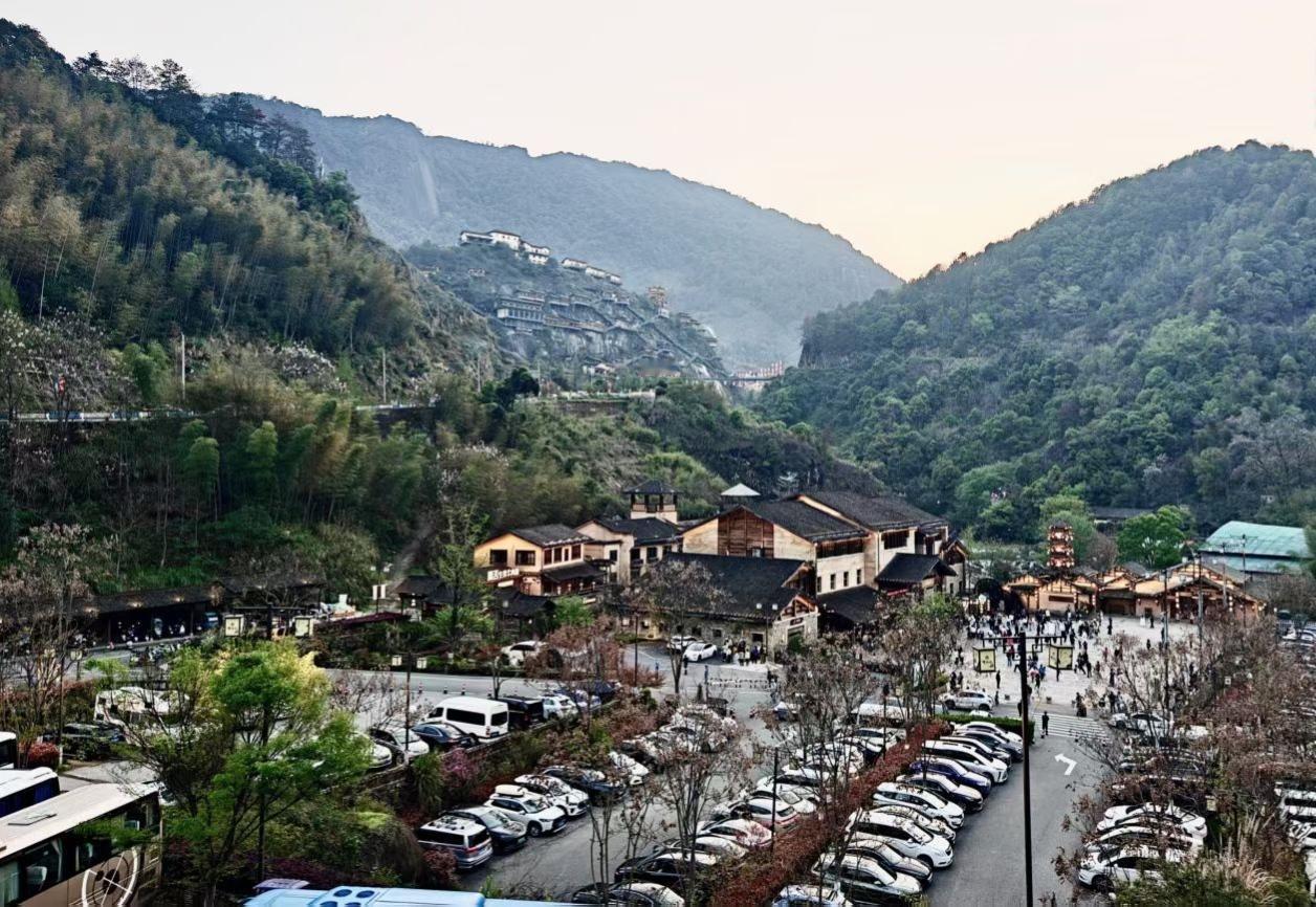 2. 站在高处望见的望仙谷，是一幅鲜活的画卷。连绵青山作底色，古朴村落嵌其间，车