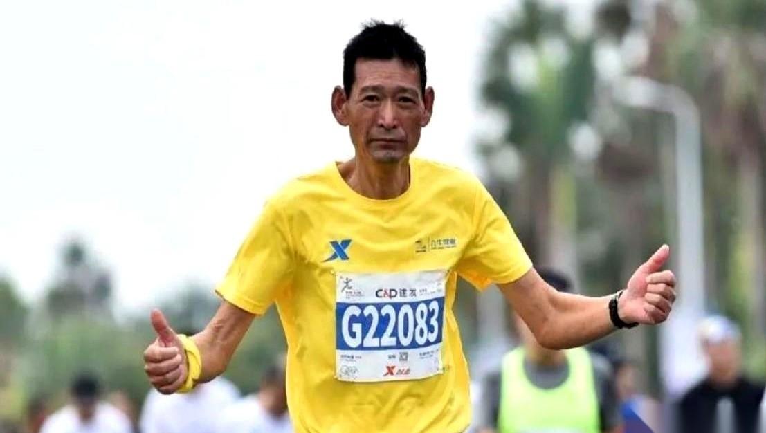 他爸的第62场马拉松，是他跑的。扛着那面“肺癌晚期，跑马抗癌”的旗，背着他爸的