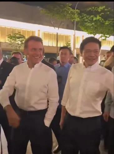 马克龙身穿白衬衫在新加坡逛夜市，出访新加坡的法国总统马克龙身穿白色衬衫，黑色西裤