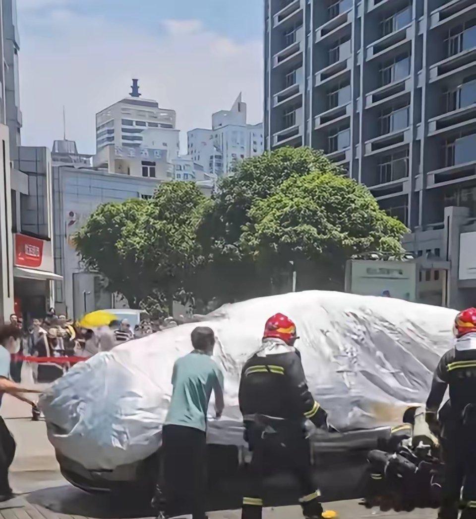 火还没彻底灭掉，消防员还在喷水，这就盖车衣了？