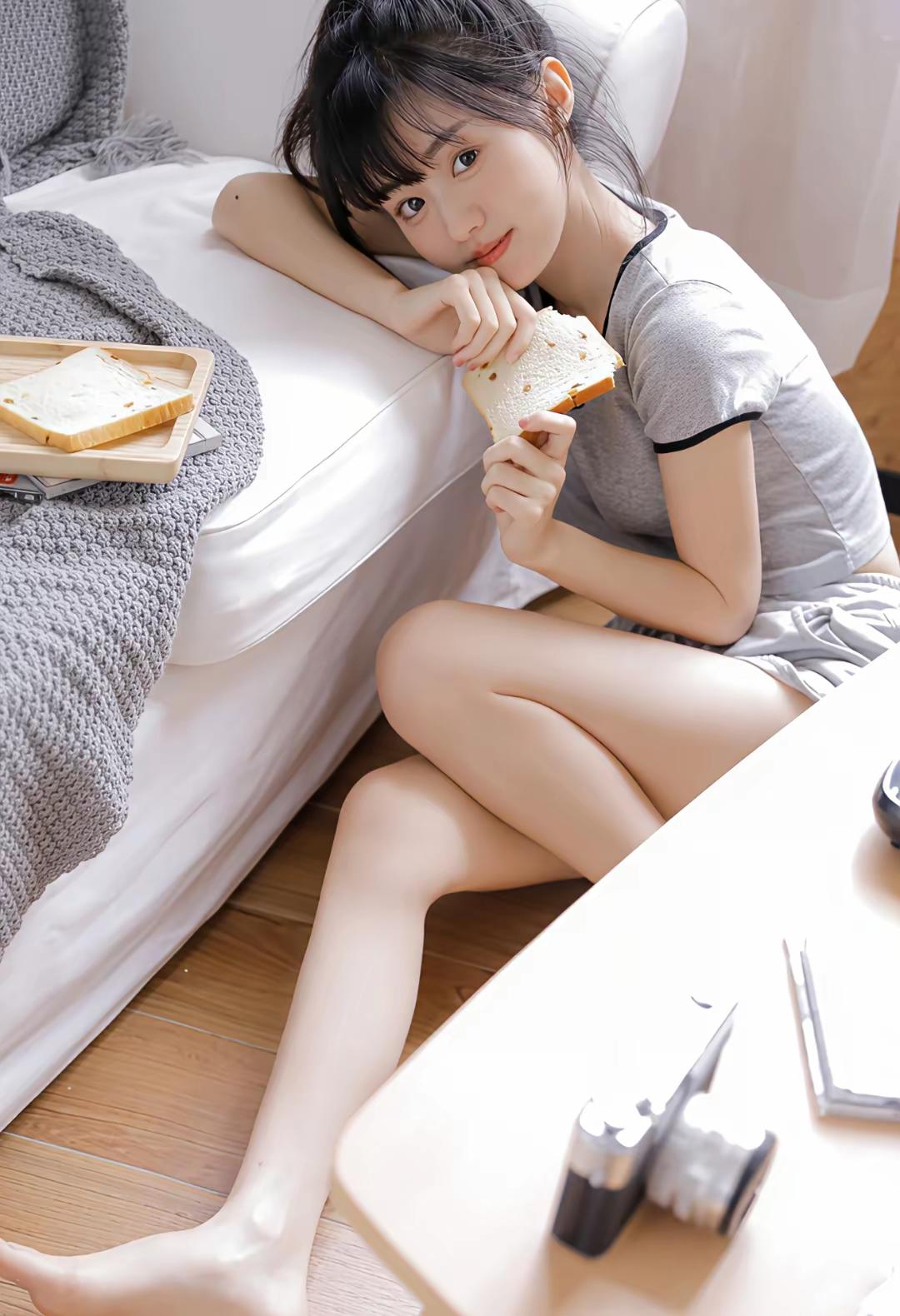 慵懒午后，阳光洒进房间，女孩在沙发上享受着美味的三明治，生活如此美好。可以分享一