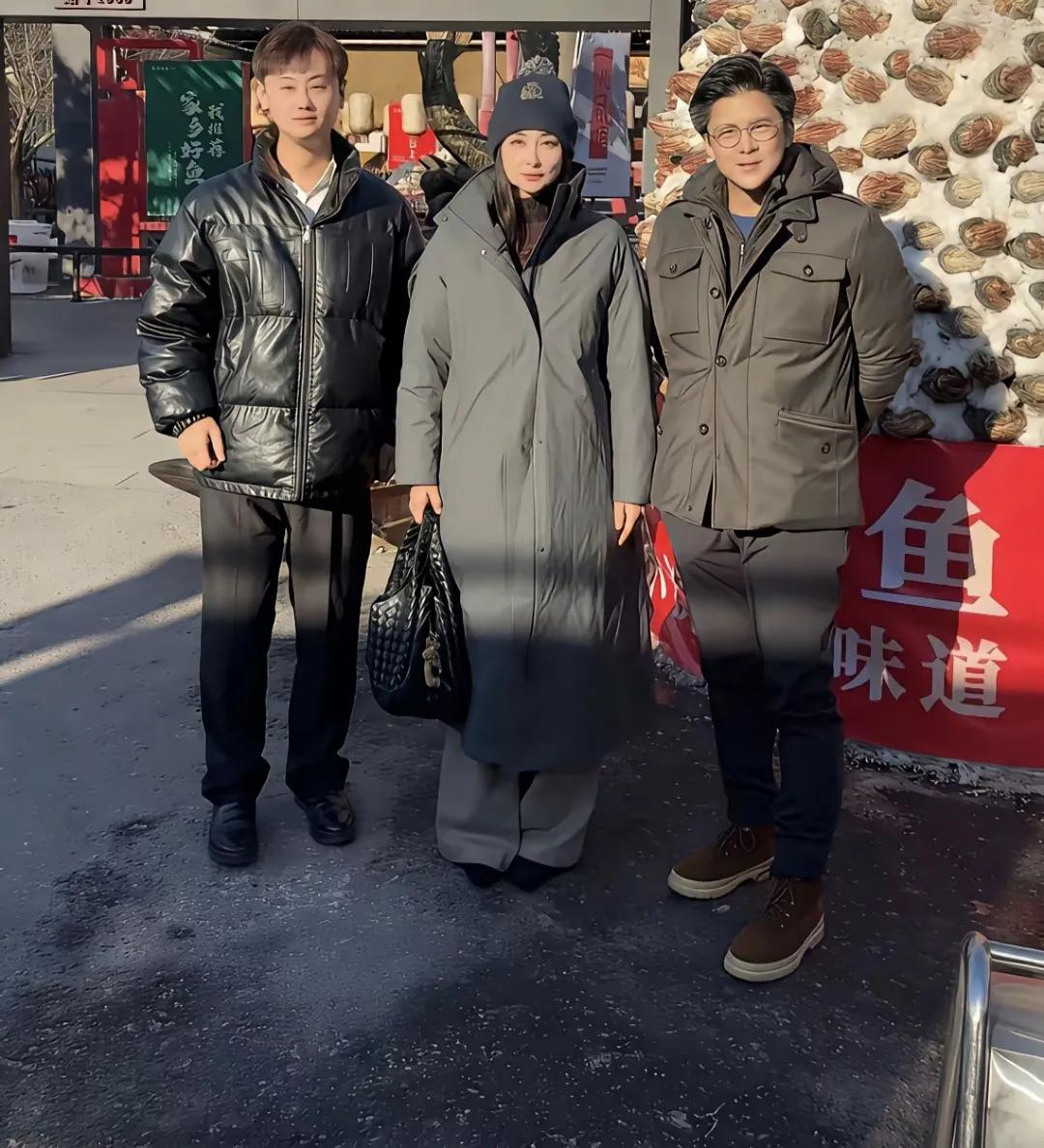 郭晶晶与霍启刚赴东北出席活动并闲逛，郭晶晶以帽子加长款羽绒服裹身，穿搭严实显怕冷