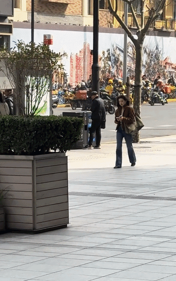 章若楠这一身时髦装扮背个超级大的包包有点搞笑！波浪卷长发搭配微喇修身牛仔裤，远远