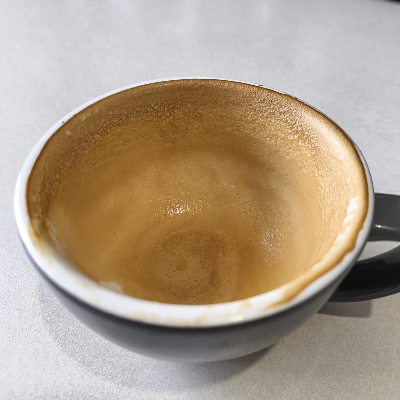 咖啡杯倒扣在盘子上，溢出的咖啡凝固成完美圆环。这其实是杯子装得太满，表面张力让液