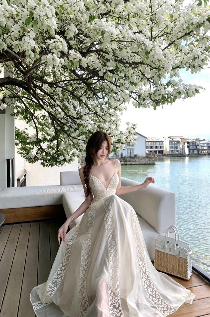 湖畔梨花漫落，白裙轻曳蕾丝边，把春日的温柔，都揉进这水天一色的风里。