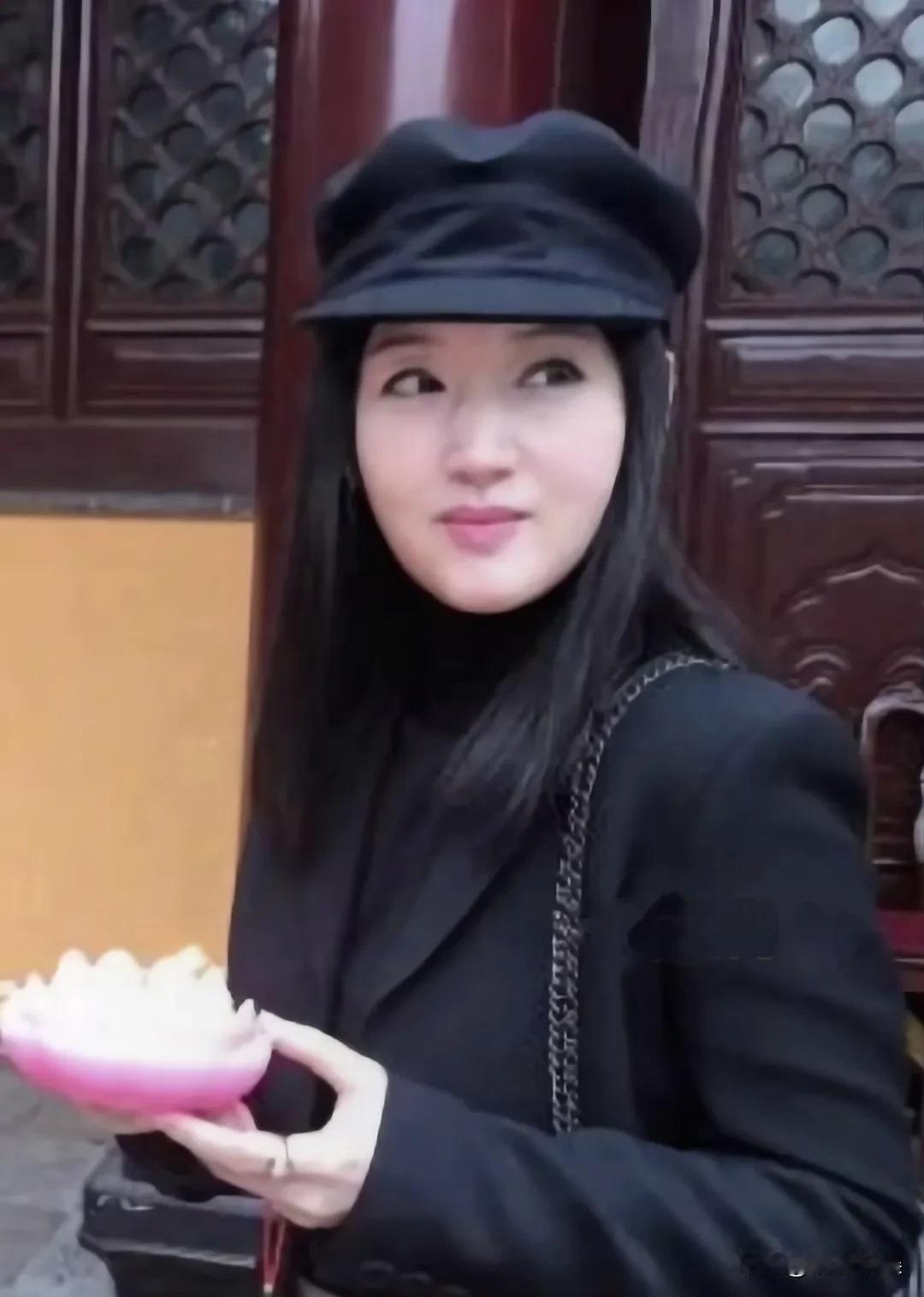 54岁的甜歌女神杨钰莹，现身寺庙拜佛。她戴着黑色贝雷帽，长发披肩，身材苗条，眉眼