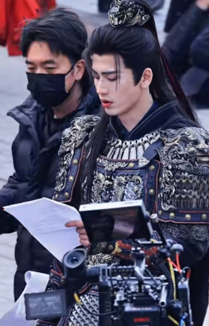 张凌赫穿着盔甲现场拿着两张A4纸在镜头前背词身边站着田曦薇替身的画面，无尽的荒