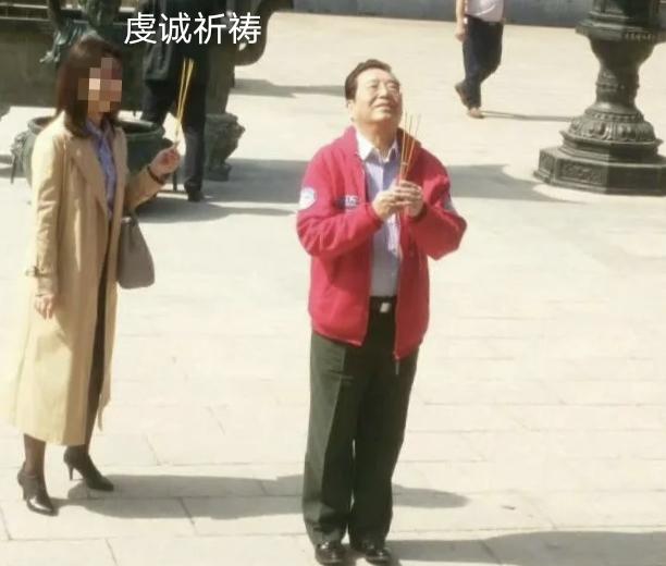 李双江顶礼膜拜·江苏隆昌寺，李双江身穿着红色上衣，下穿绿色军裤，双手捧着三柱香