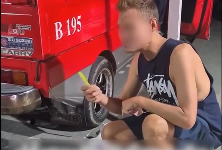 可悲的白人竟然沦落到在泰国路边捡垃圾吃，这个白人蹲在路边在捡沟里的食物吃，本地泰