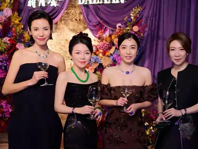 46岁的甘比以酒红色旗袍礼服搭配帝王紫翡翠珠宝惊艳亮相，四千港币的平价礼服与顶级