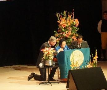 2015年，诺贝尔获奖者屠呦呦受邀发表演讲，然而，由于话筒线不够长，她只能弯着腰