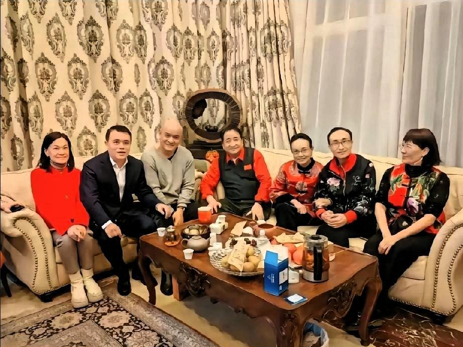 洛杉矶豪宅后院。姜昆对着烧烤架唱《我和我的祖国》。泳池水映着棕榈树，安保摄像