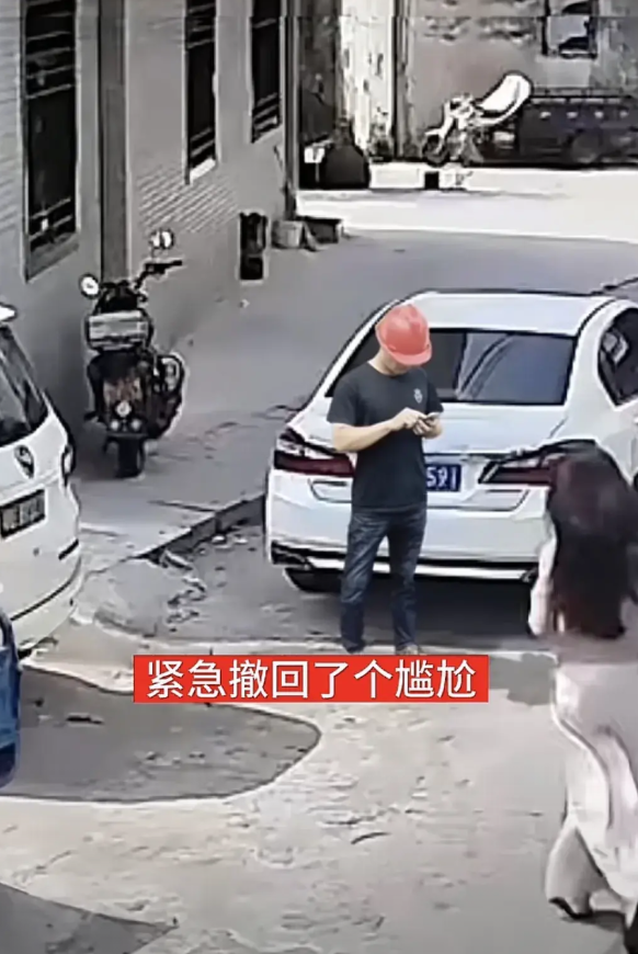 紧急撤回了个尴尬～男子站在那里看手机，一位女子从身旁经过不慎摔倒，男子准备扶时