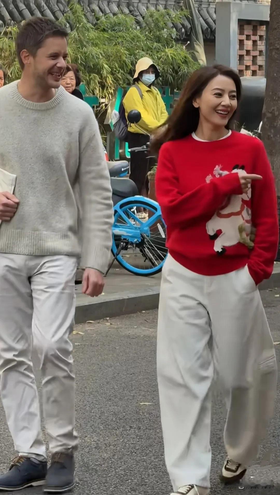 46岁的高圆圆和朋友现身成都，身穿红色毛衣配白色阔腿裤，脚踩休闲鞋，身材高瘦，走