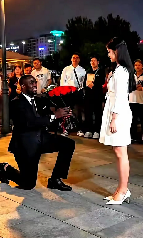 姑娘拒绝了男人的求爱！帅气小伙身穿正式的西装和皮鞋，手捧鲜花单膝下跪，露出一口