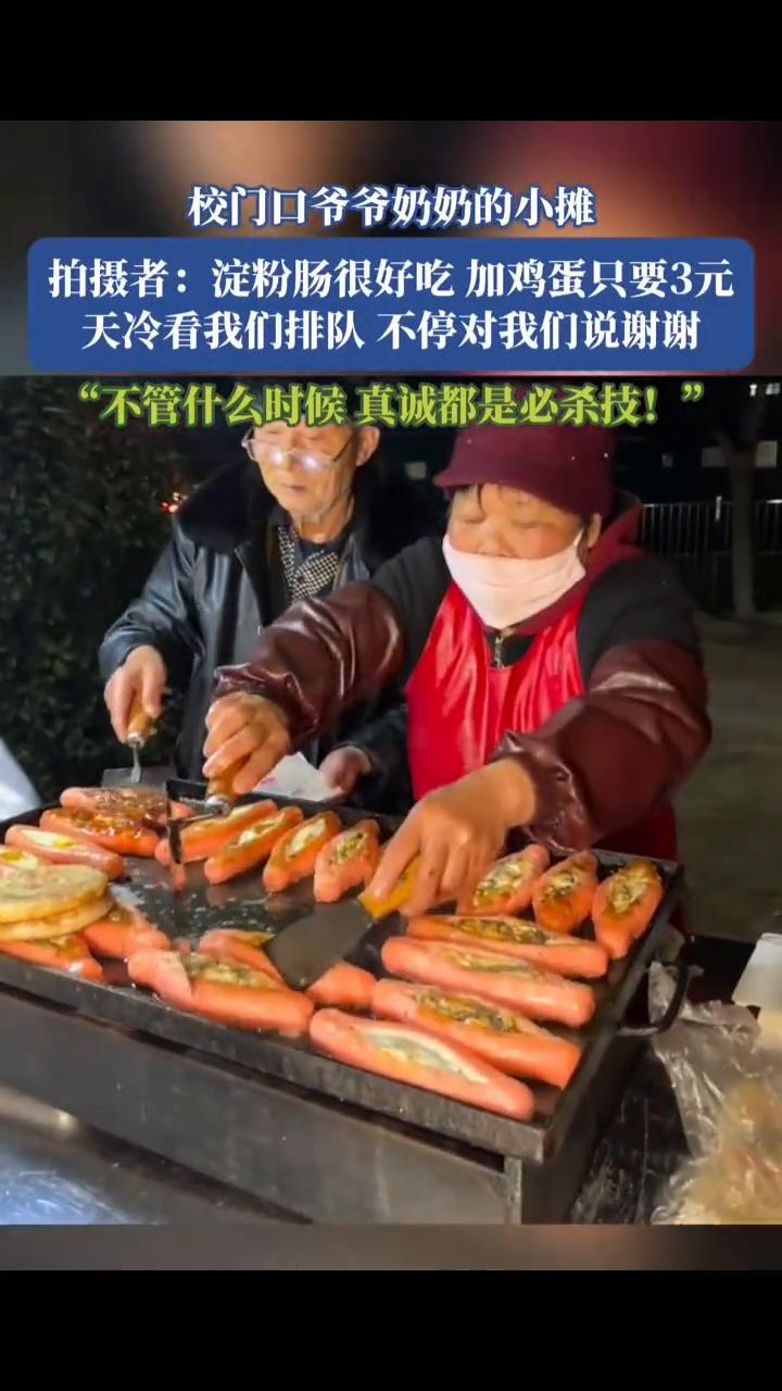 校门口爷爷奶奶的小摊，拍摄者：淀粉肠很好吃，加鸡蛋只要3元。天冷看我们排队不停对