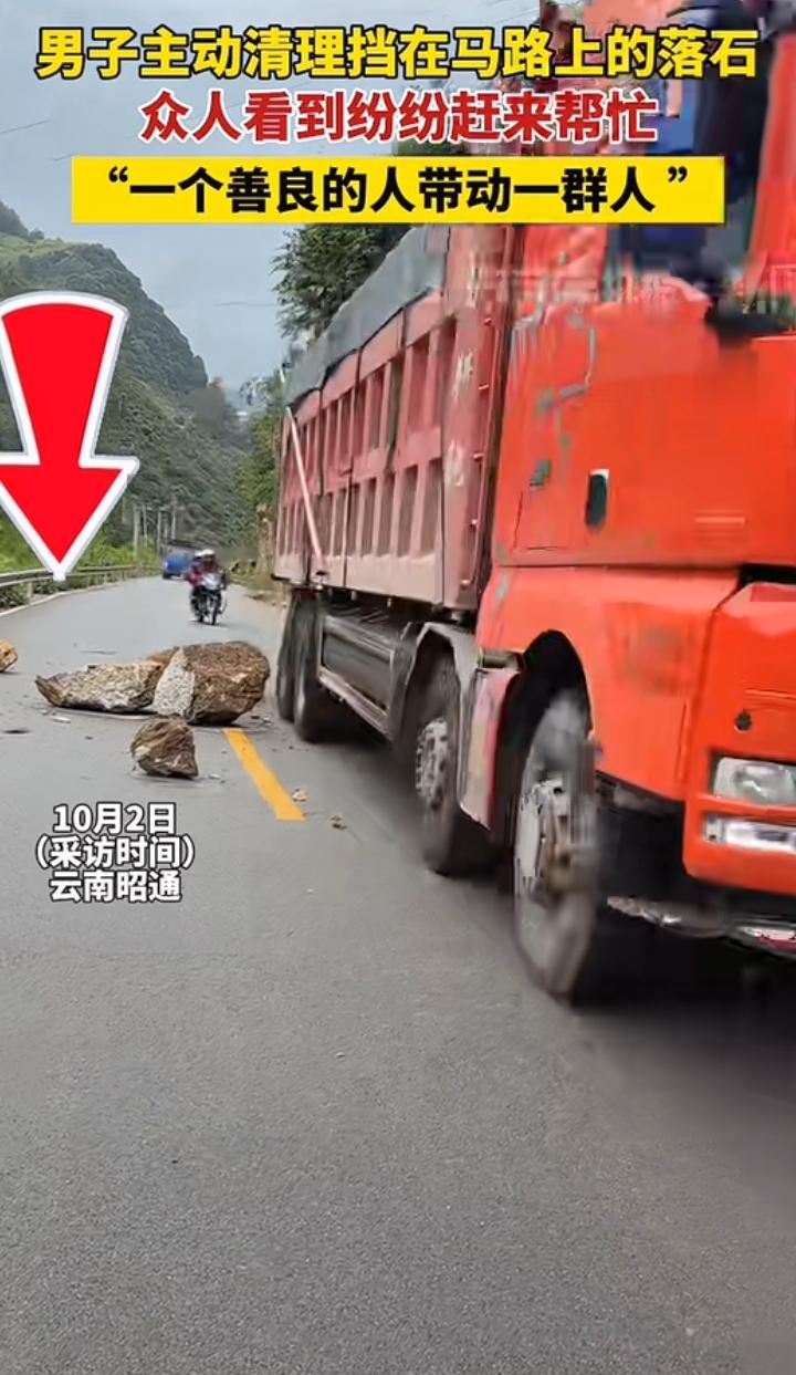 云南昭通一名男子在路过自己家附近的乡村公路时，看到有几块落石心想这多不安全啊！必