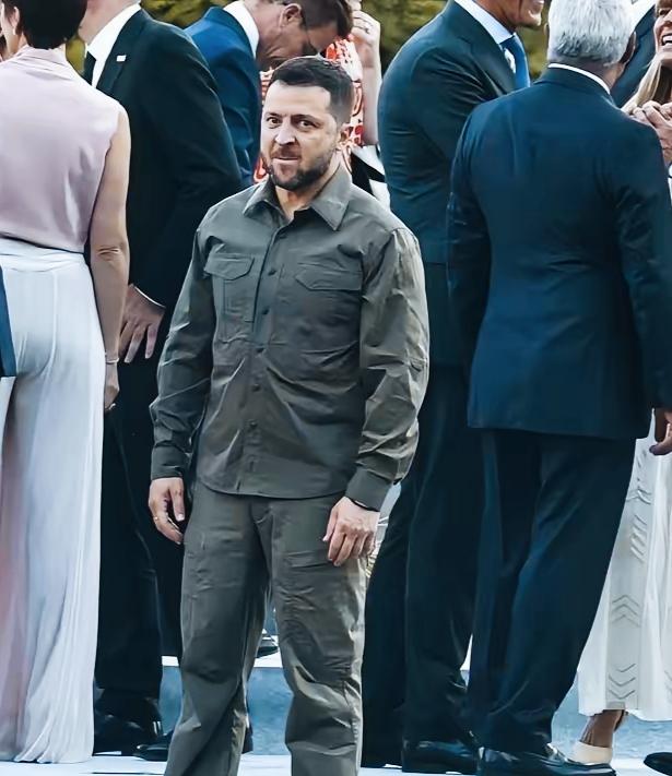 泽连斯基这是在思考什么问题呢？其他人都在相互聊天交流，泽连斯基自己站那陷入了沉