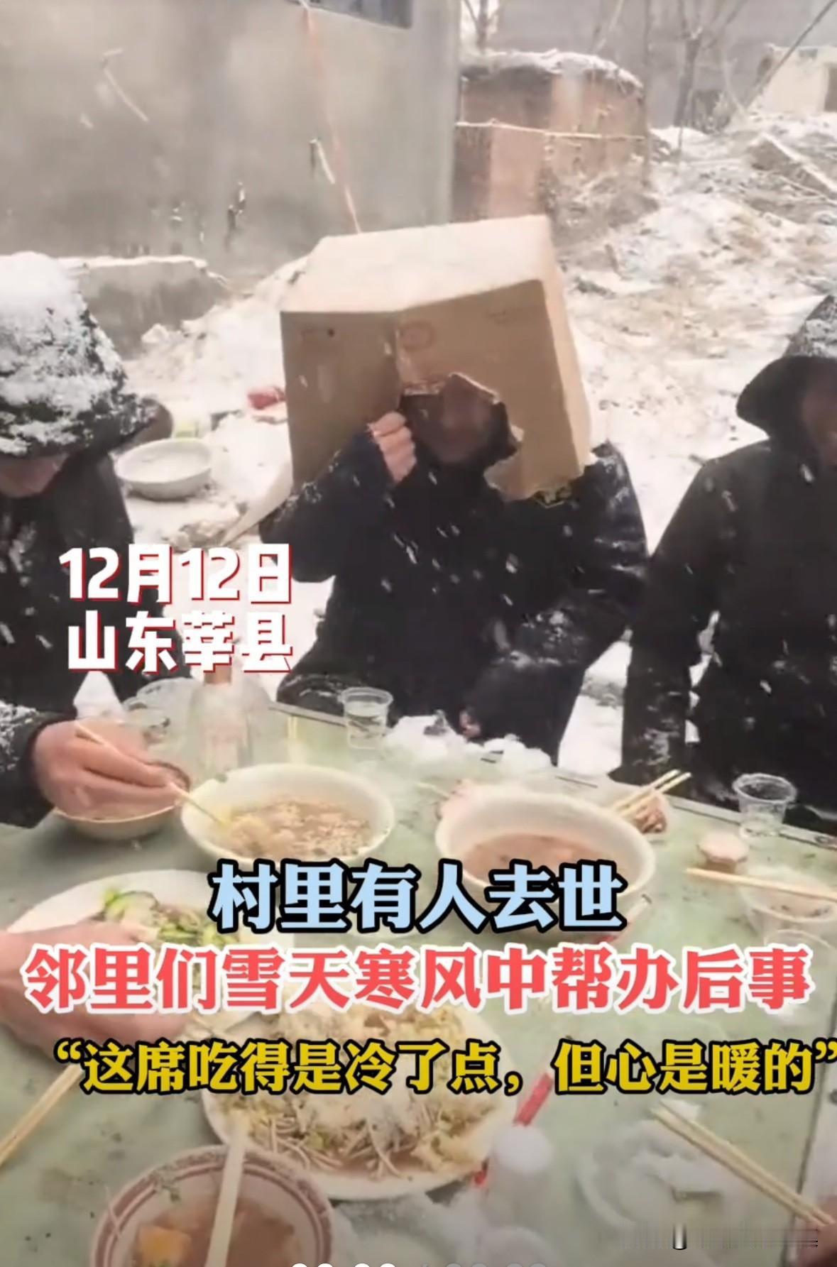 农村有老人去世，来帮忙的乡亲们冰天雪地里帮忙办后事，但是冒着雪吃席，确实有点冷。