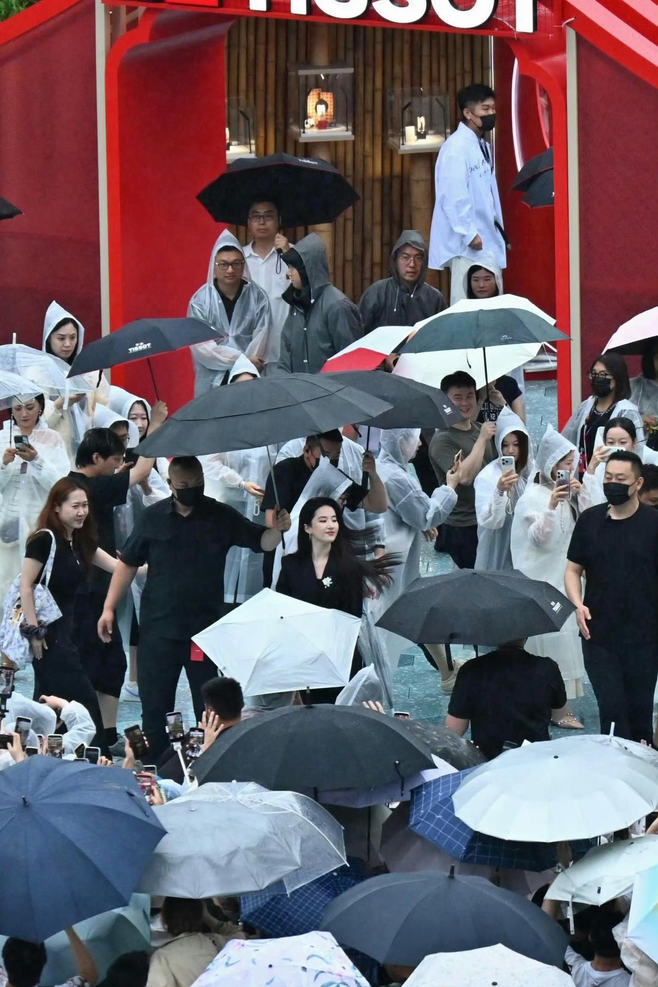 滂沱大雨也挡不住的氛围感✨刘亦菲雨中现身活动，四周伞海林立，黑衣安保随行，现