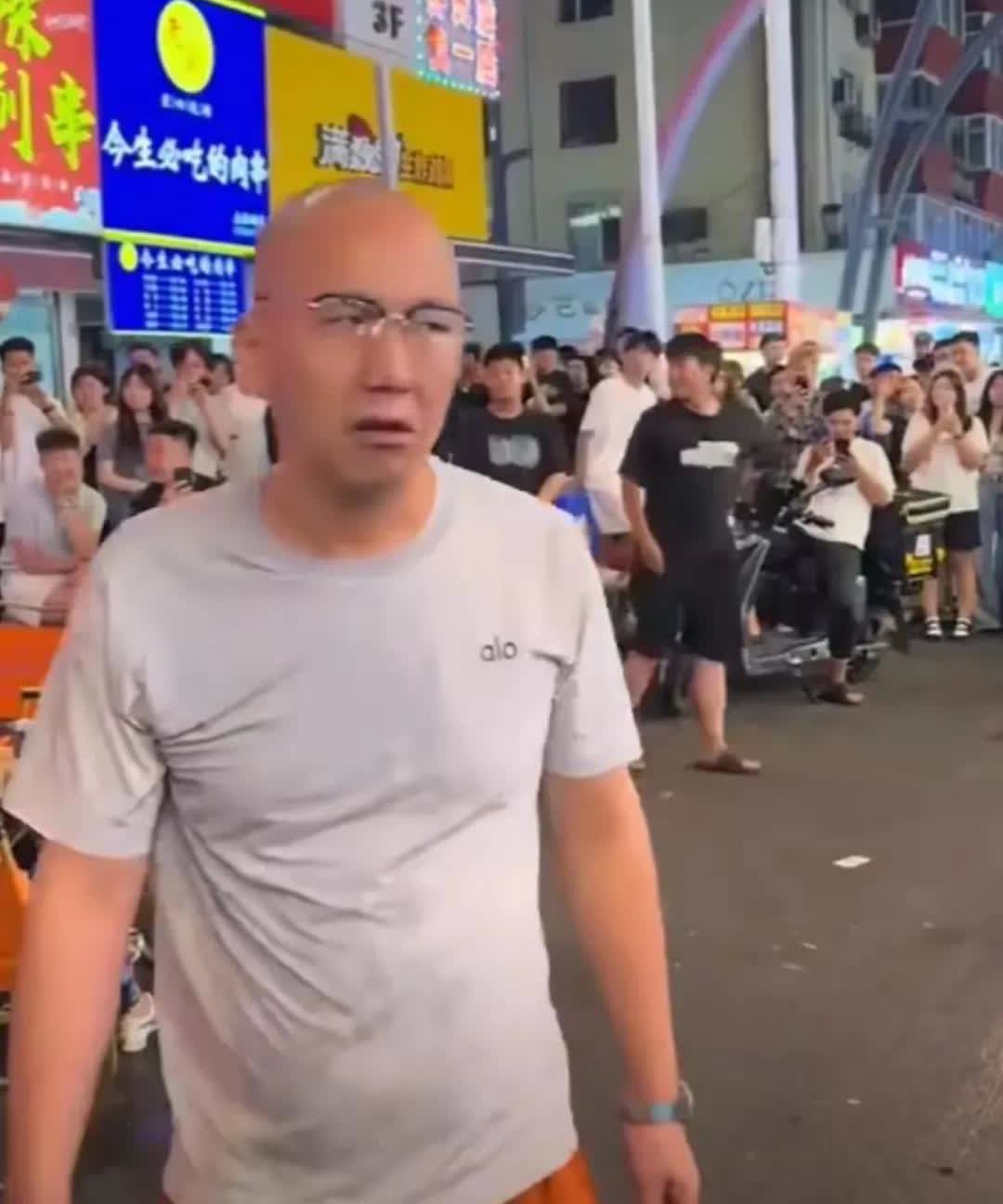 给外国人磕头的光头男……7月14日晚上，在吉林长春桂林街头，一位光头男子