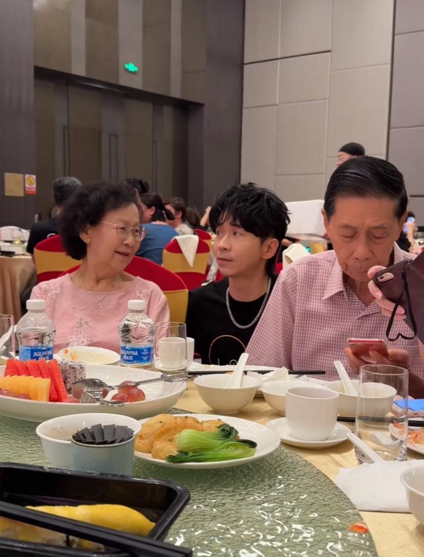 光良蹲在爸妈身边，像一个小孩子一样，真的好可爱啊。光良今年都55岁了，看
