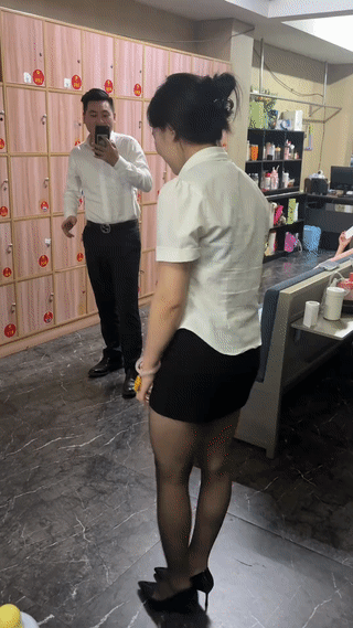 一名在足疗店工作的年轻女子正在她的男同事面前展示她的独门绝活:“一字马”？整个