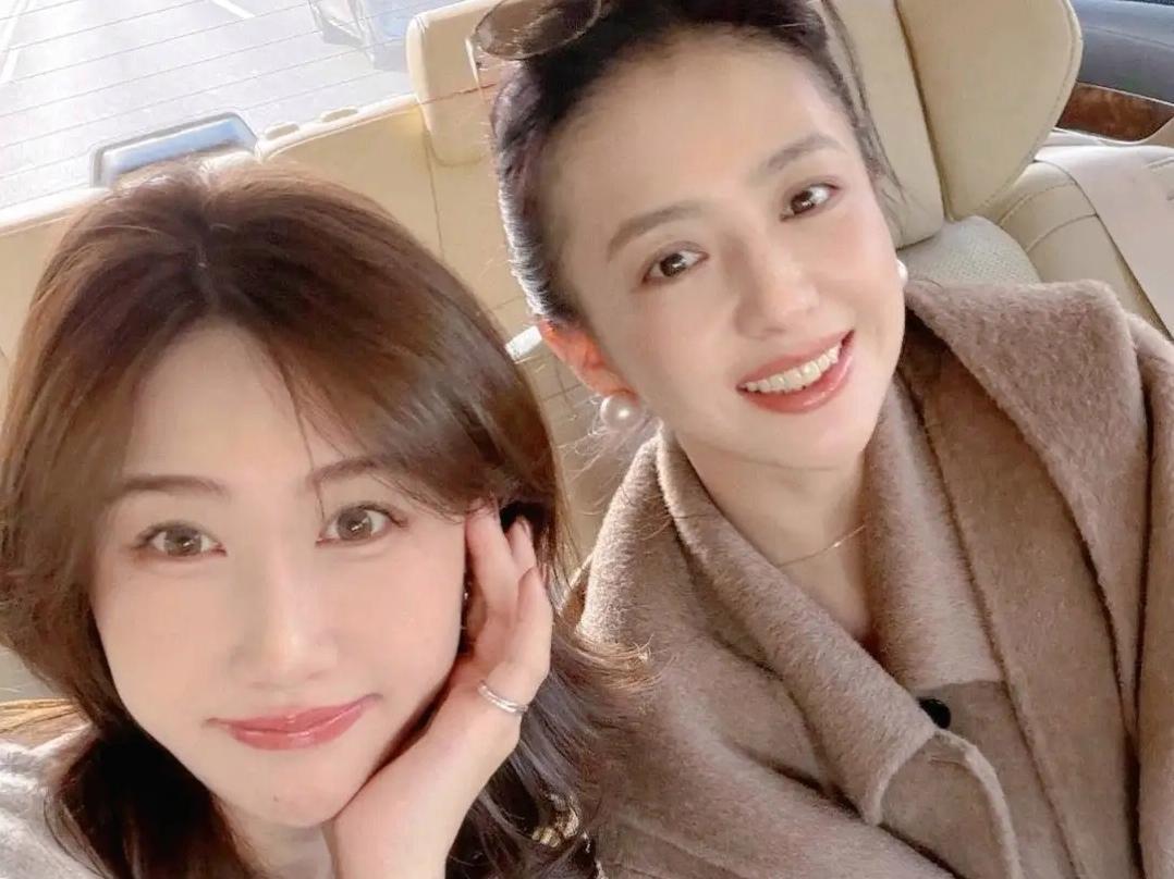 42岁佟丽娅和朋友逛街买衣服，她身穿毛呢大衣，扎丸子头好美