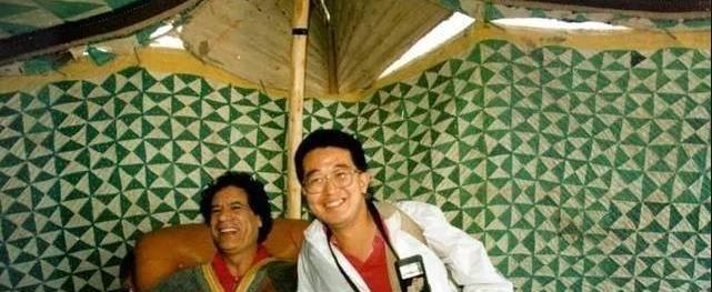 1992年，中国记者唐师曾与卡扎菲合影并请他签名，卡扎菲签完名递给唐，并拍拍他的