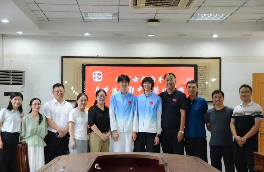 女排亚运会冠军成员吴梦洁和郭中楠9月27日回到母校南通市田家炳初级中学参加欢庆活动，校长王丽和师生代