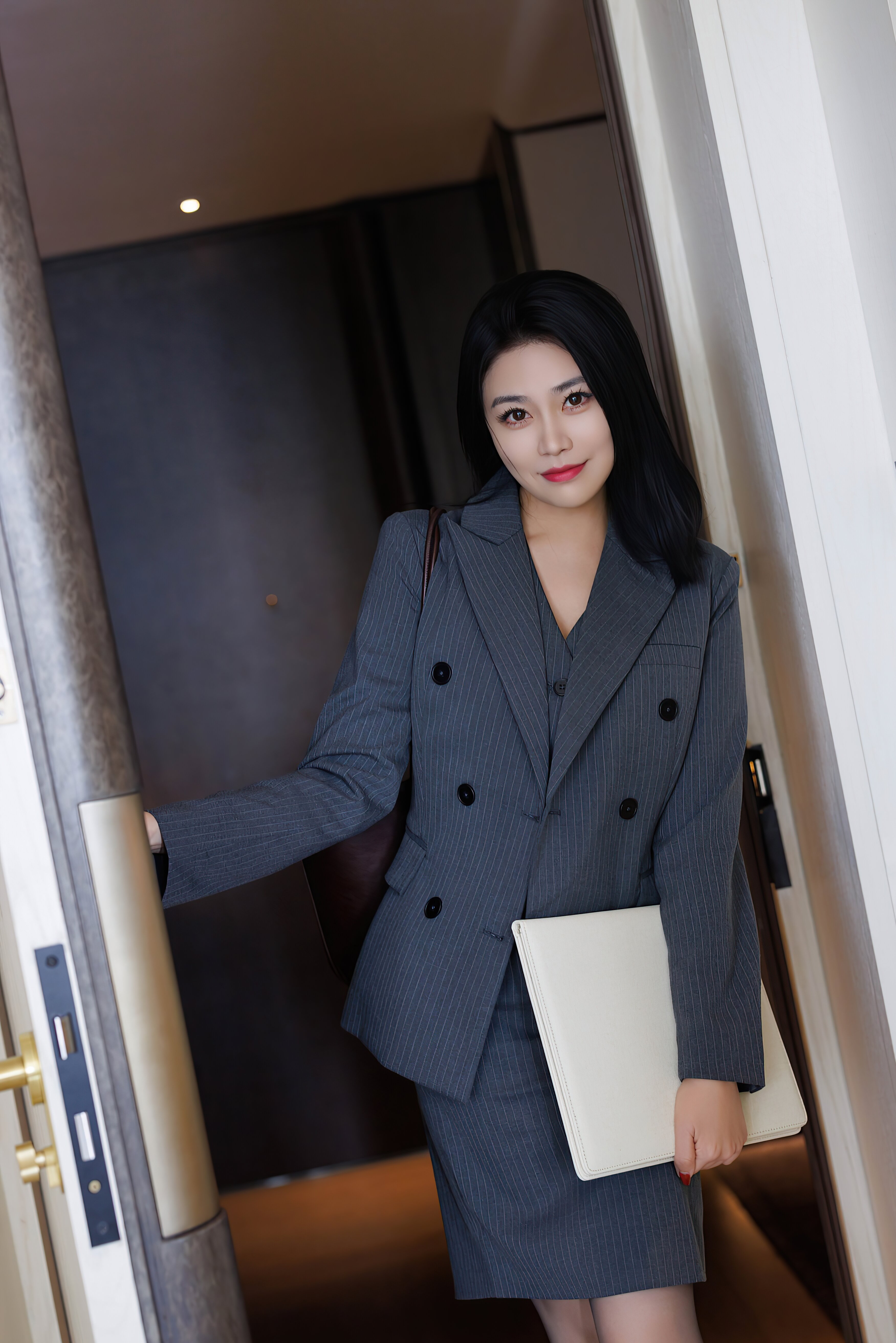 穿灰色职业套装配黑丝高跟鞋的职业女性