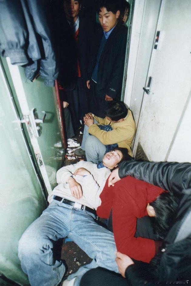 2001年，春运期间拥挤的列车上，乘客睡在过道的地上。