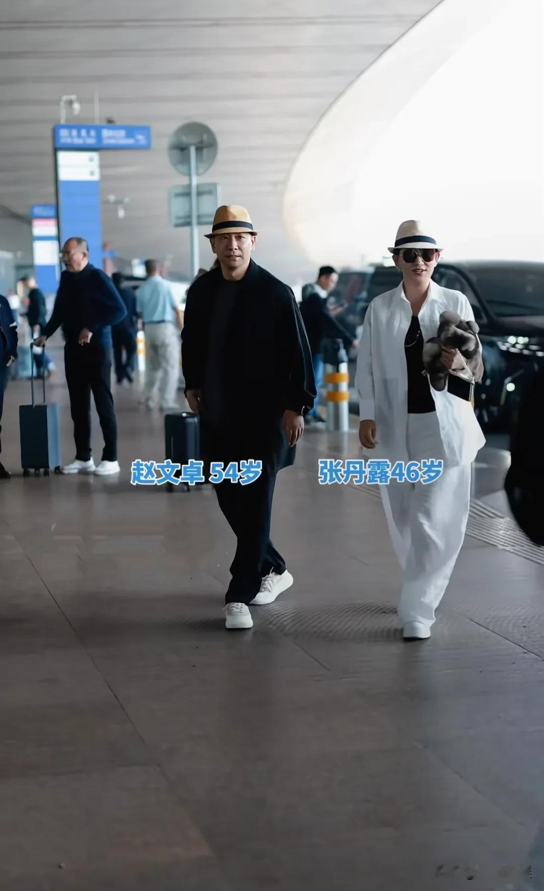 赵文卓、张丹露夫妻俩现身北京机场，接从香港放假回来的大女儿玫瑰。夫妻俩一黑一白