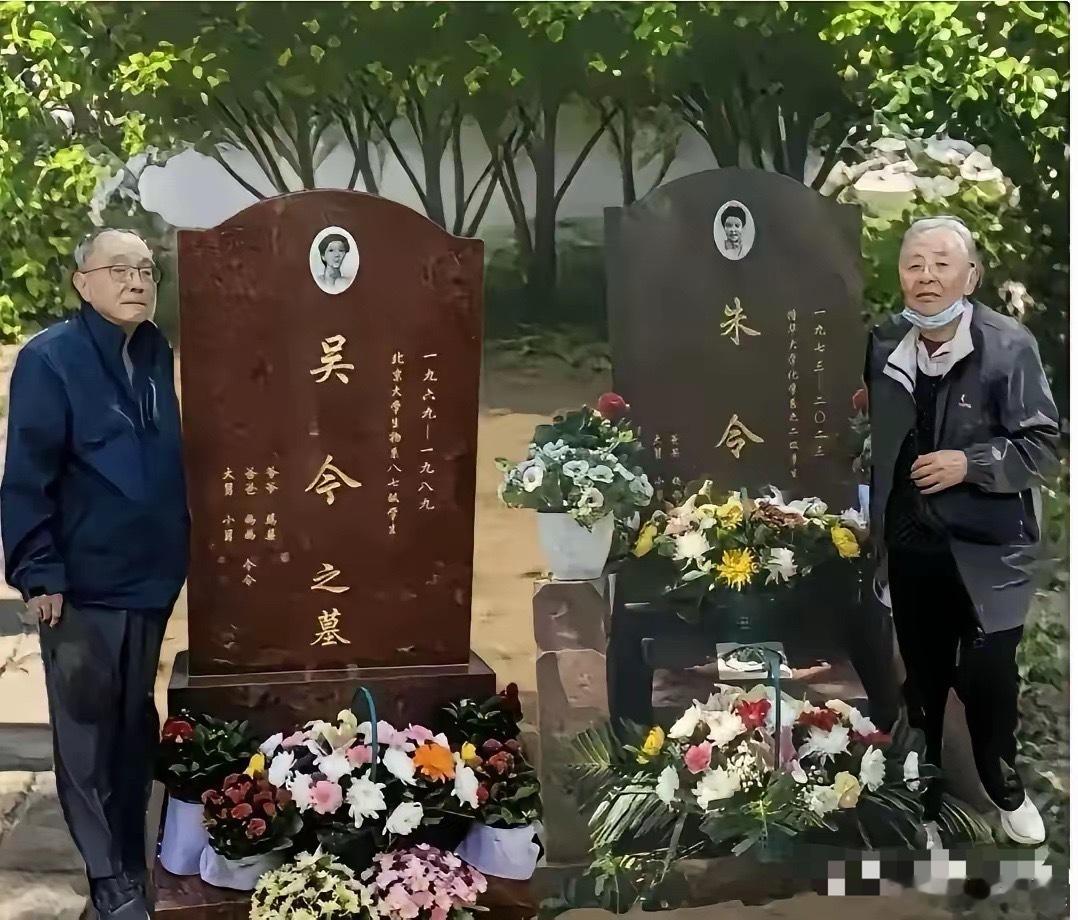 这是朱令父母在万安公墓为两个女儿扫墓的场景。照片中，两位老人站在两座墓碑前，左边