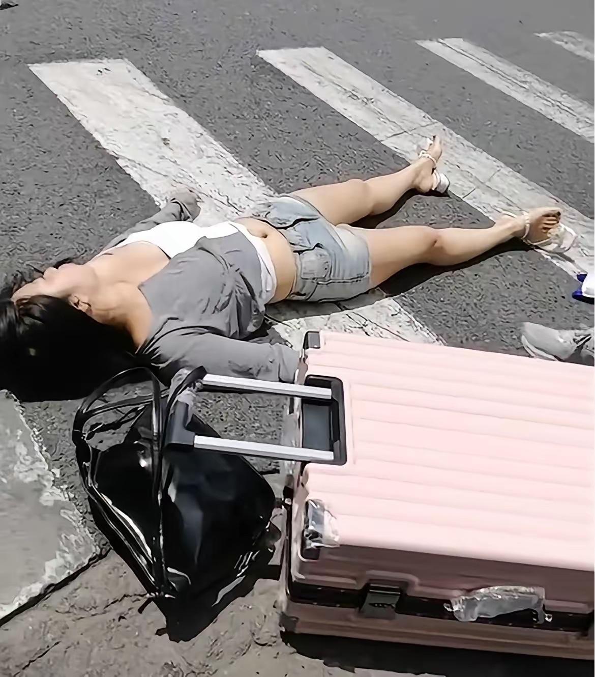 是什么让现在人让变得如此冷漠和无情…看到一位女子躺在马路中间行李箱和包包散落