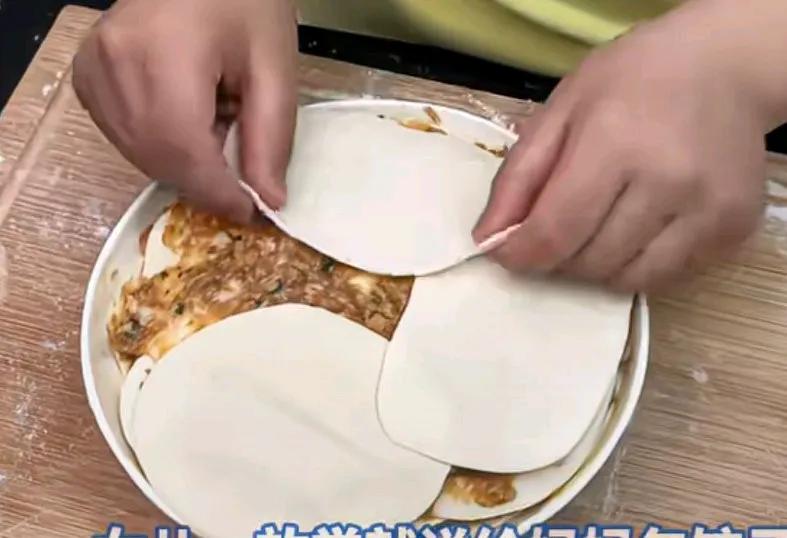 女孩一放学就说给妈妈包饺子吃，只见女儿把饺子皮叠加铺在盘子上，把饺子馅抹在了饺