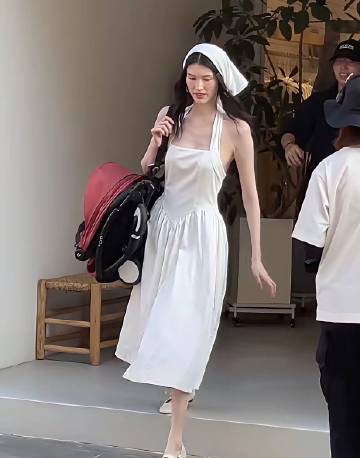 何穗身穿一身白推着婴儿车，也许是想营造出油画田园少女风吧，头上还搭配着...