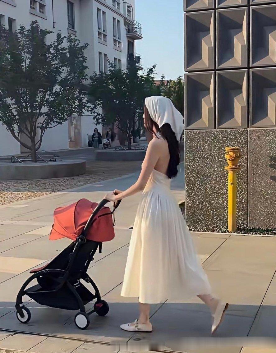 何穗推着婴儿车穿了一身白，还配了同款头巾，估计想弄出油画田园少女那味儿。