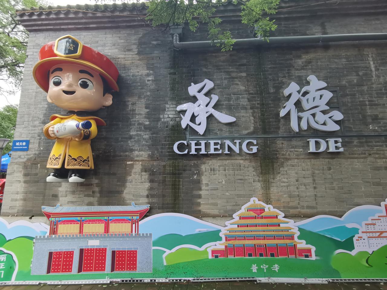 避暑山庄城关门对面有了文创，但还远远不够。从城关门出来，对面墙上映入眼帘的是