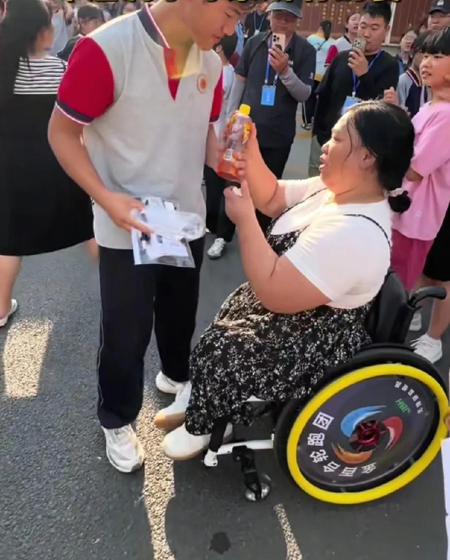 即将走进高考考场的男孩，跟坐着轮椅来陪考的妈妈挥了挥手，妈妈的一个举动，让旁边陪
